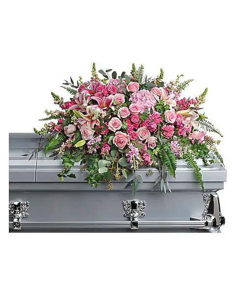 Silver casket with a large floral arrangement of pink and green flowers on a white background