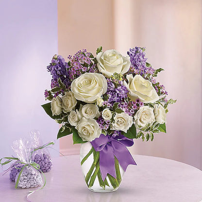 white roses and purple flowers in a  vase